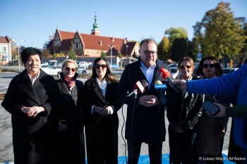 Konferencja prasowa władz miasta na parkingu.