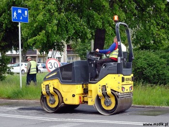 Nowy asfalt podczas wyrównywania przez walec.
