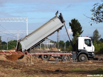 Wywrotki przywożą materiały na plac budowy.