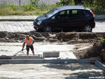 Ustawianie kolejnych betonowych krawężników.